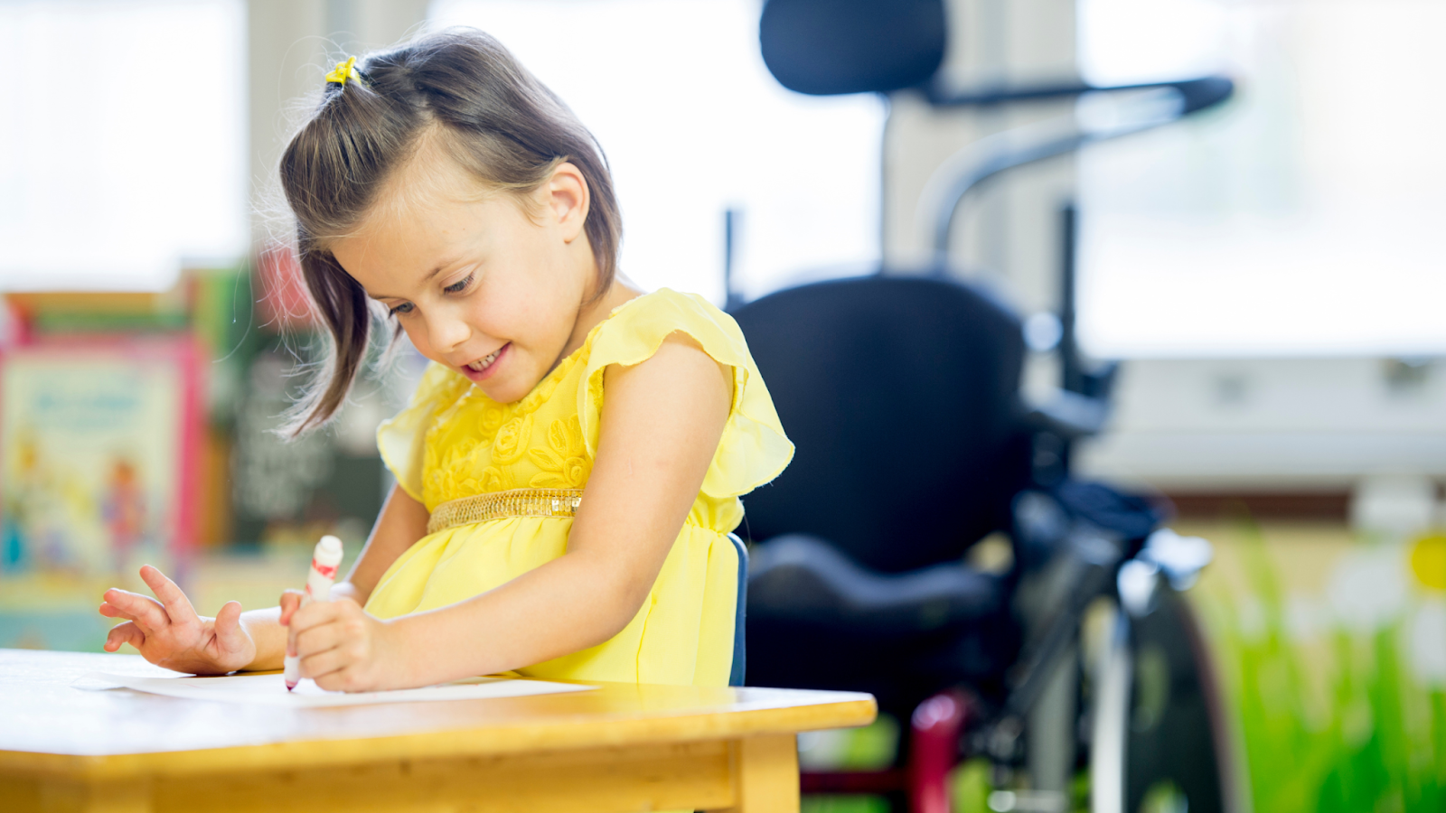 girl with cerebral palsy sitting at a table coloring