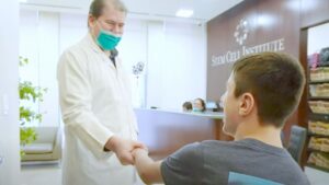 Owen shaking the doctor's hand at Stem Cell Institute Panama