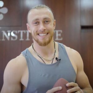 George Kittle smiling with a football at Stem Cell Institute Panama