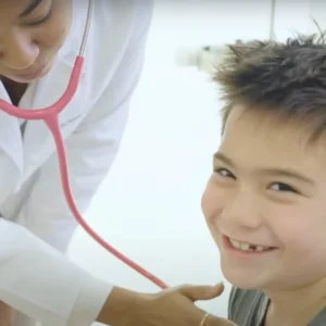 Young boy smiling as doctor listens to his heart at Stem Cell Institute Panama