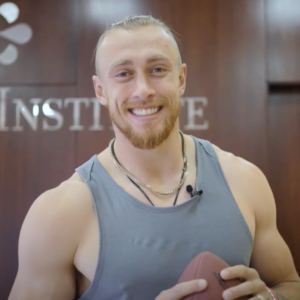 George Kittle smiling with a football at Stem Cell Institute Panama
