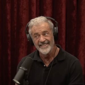 joe rogan stem cell Mel Gibson in front of a red curtain being interviewed by Joe Rogan