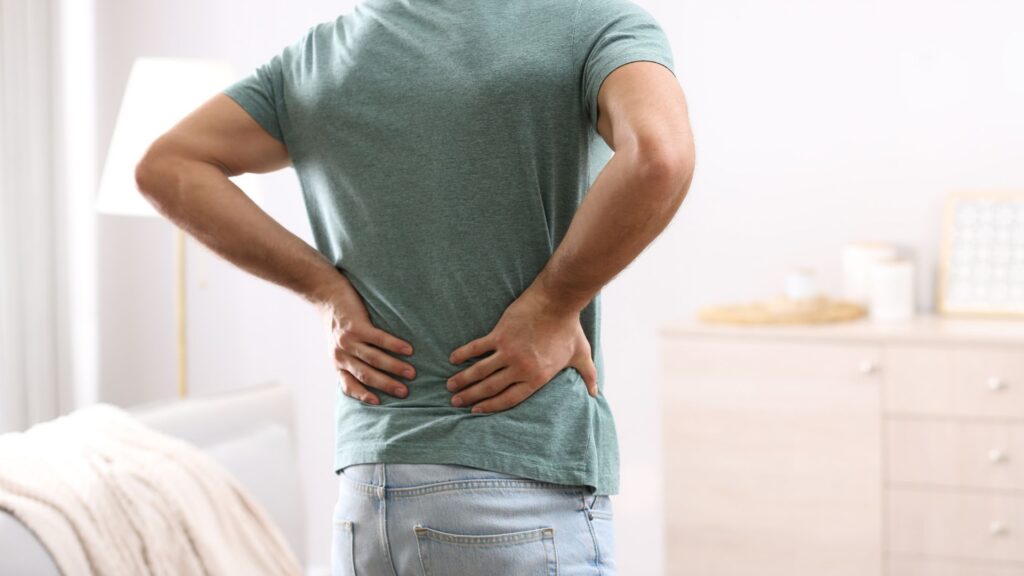 man suffering from back pain at home