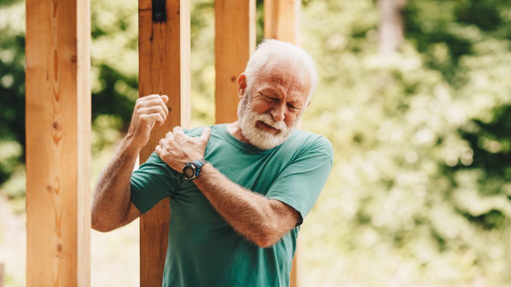 senior man suffering with shoulder pain during a workout