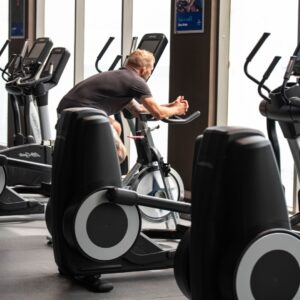man resting on a stationary bike in between exercises