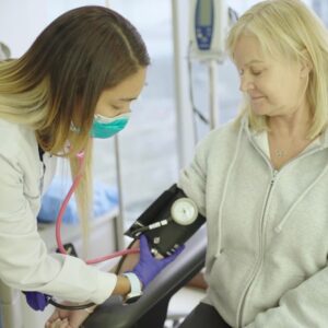 older woman having her blood pressure checked by a medical specialist