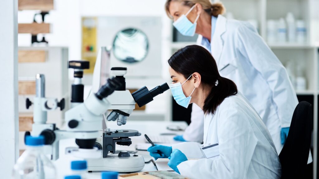regenerative medicine young scientist working in a lab with her colleague in the background