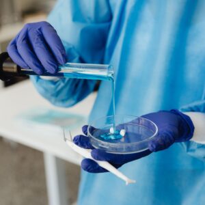 mesenchymal stem cells medical researcher pouring blue liquid into a petri dish