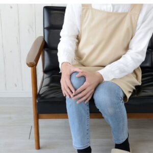 stem cell therapy for knees woman sitting on a couch holding her knee in pain