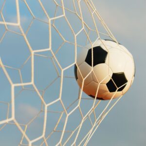soccer ball being kicked into a net