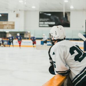 hockey player watching the game from the box